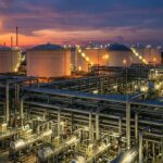 API Standards implemented in a modern oil and gas refinery showing storage tanks and piping systems.