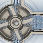 High-pressure centrifugal pump cavitation occurring on stainless steel impeller blades.