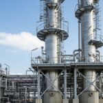Tall industrial distillation column tower at a chemical processing plant