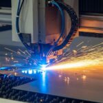 Fiber laser cutting machine fabricating a sheet metal part with sparks flying.