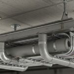 Heavy-duty steel trapeze hanger supporting multiple insulated pipes and conduits suspended from a ceiling.