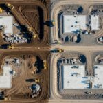 Aerial view of a BESS facility construction site showing earthwork grading, soil compaction, and site preparation for battery storage containers.