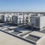 Utility-scale BESS container units installed on reinforced concrete slab foundations at a solar-plus-storage project site.