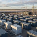 Utility-scale battery energy storage system containers integrated with a solar photovoltaic power plant for grid stability.