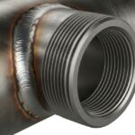 A forged steel threadolet fitting welded to a main run pipe showing internal threads.
