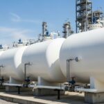 Large white horizontal LPG bullet storage tanks at an industrial petrochemical plant.