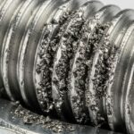 Severe metal galling damage on a stainless steel threaded bolt and nut.