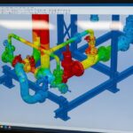 3D CAD model of an industrial piping system showing color-coded stress analysis on a computer screen.