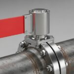 Mechanical intrusive pig signaller with a visual flag indicator mounted on an industrial pipeline.