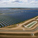 Aerial view of a utility-scale solar farm showing integrated drainage channels, detention basins, and erosion control measures protecting PV rows.