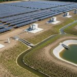 Utility-scale solar farm site layout showing elevated tracker systems and engineered drainage basins for flood protection.