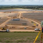 Professional surveyor conducting Topographical Surveys for Solar Projects on a large-scale utility site with complex terrain.