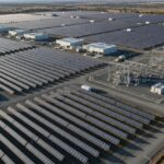 Aerial view of a large-scale utility solar power plant showing PV arrays and substation infrastructure.